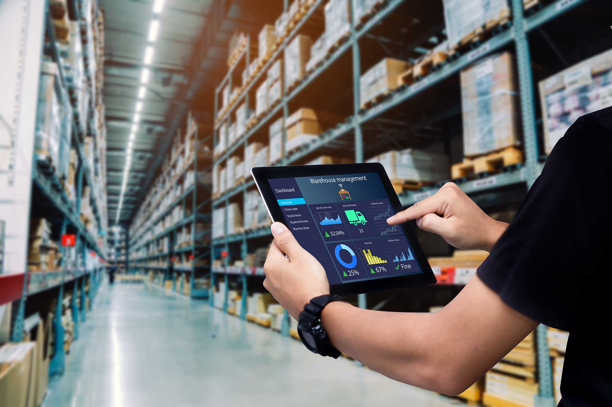 man walking through warehouse with an iPad showing warehouse management software